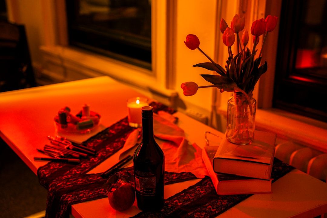 Stämningsfull påskdukning med röda tulpaner och tända ljus på ett bord.